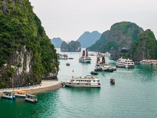 Numerous cruise boats and traditional junk boats anchored in Halong Bay