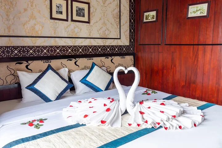 Cabin bed decorated with swan towels and red rose petals